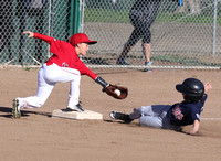 Sean Epps of the Twins slides under the tag of Ethan Yen of the Angels in a close play while stealing 3rd base.  This occurred during a Granada Little League game in the AAA division.