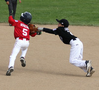 Danny Schaecher of the Angels tries to avoid the tag of second baseman Vinny Carbonaro of the Rockies in Granada Little League AAA action.