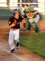 Elliott Hall runs to first base following a bunt as catcher Denny Derham fields the ball in a Granada Little League game between the Giants and Red Sox.  Each year, each of the GLL Majors teams play a